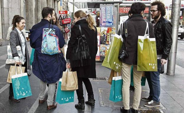 Un grupo de consumidores charlan en la Gran Vía de Madrid.