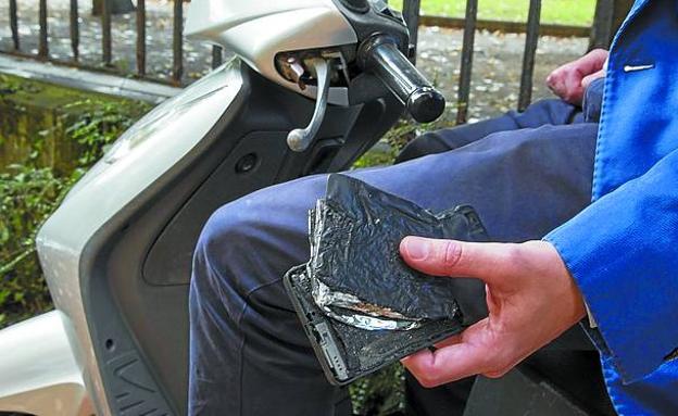 Xabier B., donostiarra de 39 años, sostiene en su mano el móvil quemado.