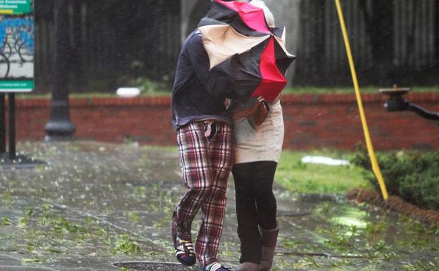 Dos personas caminan bajo el temporal./Reuters