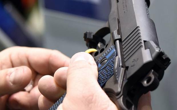 Una persona inspecciona una pistola Colt en la feria de Tiro y Caza de la Fundación Nacional de Deportes de Tiro, en Las Vegas. /Ethan Miller (Afp)