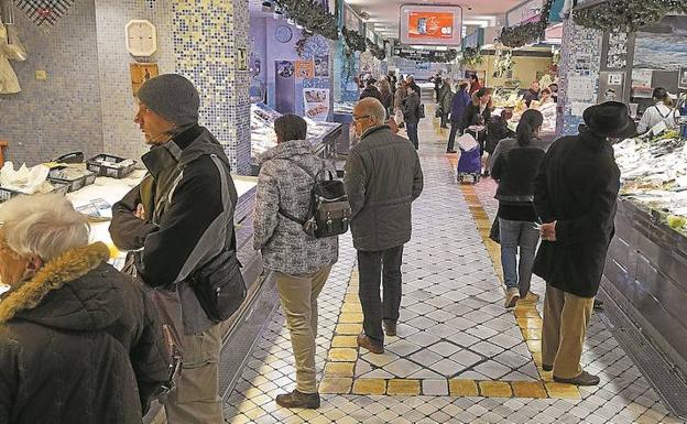 Varios clientes ultiman sus compras navideñas en el mercado donostiarra de La Bretxa. /Lobo Altuna