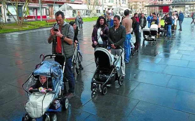 Los bebés y sus aitas y amas hicieron cola frente al Ayuntamiento para recibir sus acebos. / F. DE LA HERA