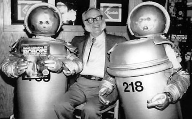 Isaac Asimov posa con dos objetos que simulan ser robots. /Archivo