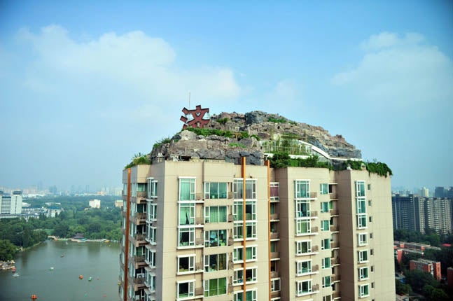 Una casa con una montaña en la azotea (China)./