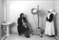 Imagen de La Gota de Leche en los años 40. Sor Teodora, una madre y su bebé, en la sala de helioterapia./