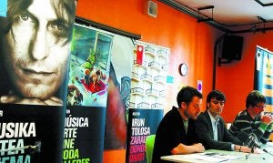 Ivan Lozano e Iñaki Artetxe, de Kutxa, y el concejal Andoni Iturzaeta, junto al cartel de Nacho Vegas, ayer, en la presentación del programa./