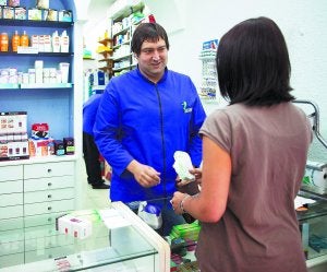 Ibon, farmacéutico de la botica de la calle Legazpi, en la capital guipuzcoana, vende unos medicamentos a una clienta. ::
USOZ/