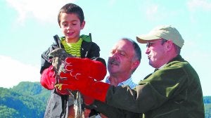 Suelta en Aia. Patxi, un niño de Deba, suelta un águila junto al diputado Rafael Uribarren y el guarda Esteban Iriarte. :: PEÑALBA/