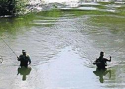Dos pescadores dentro del río./