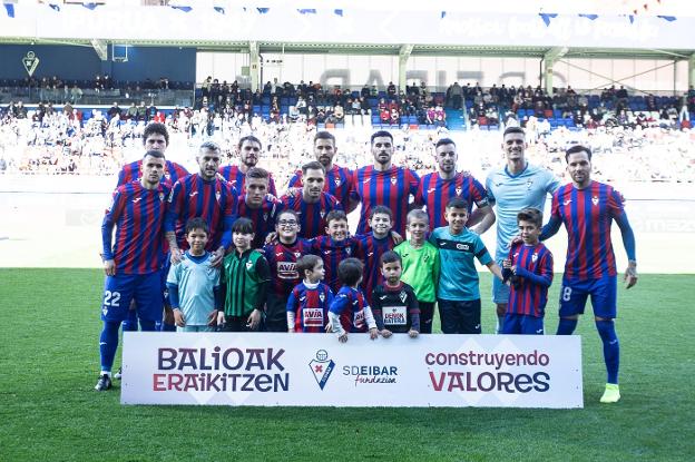El once inicial del Eibar ante el Amorebieta con un grupo infantil, que les animó todo el partido. 