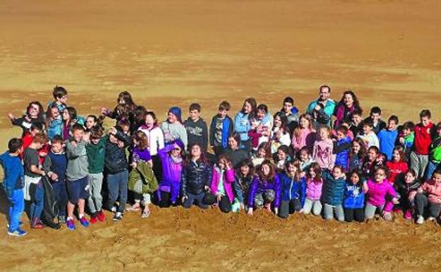 Alumnos de 5º y 6º de la Ikastola Salbatore Mitxelena de Zarautz, durante la recogida de plástico de ayer en la playa. / ETXEBERRIA 