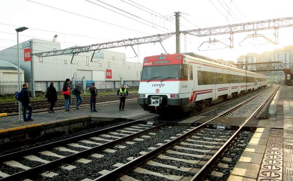 Viajeros esperan que el tren del que acaban de bajar continúe en dirección Irun para atravesar el pasa en la estación de Pasaia/Arizmendi