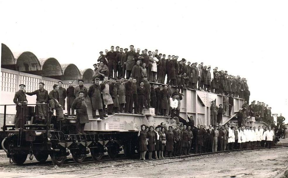 Gran parte de la plantilla de Herederos de Ramón Múgica posa en 1966 con 'el ciempiés', un vagón diseñado para poder transportar grandes cargas. /ARCHIVO FAMILIA OHLSSON