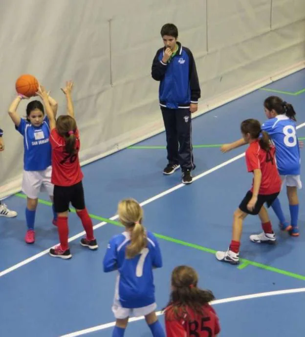 Dos equipos de niñas disputan un partido de baloncesto. /