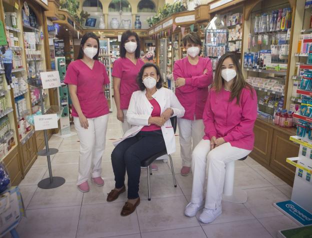 Feli, en el centro, rodeada de su equipo en la farmacia del Paseo de Colón donde mantiene su ilusión intacta. / F. DE LA HERA