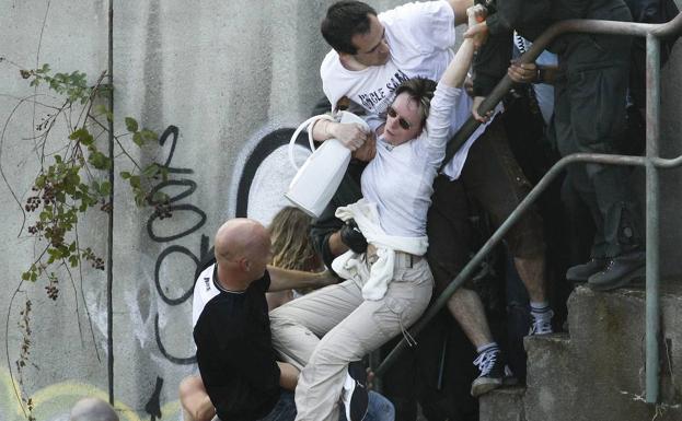 Una década de la tragedia del Love Parade 1 Varias personas tratan de evacuar a una mujer.
