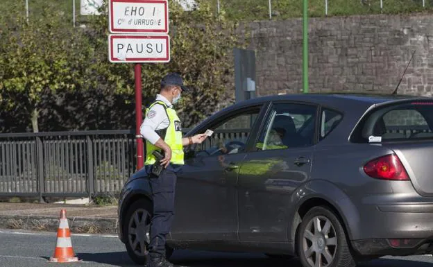 Un gendarme pide la documentación a un conductor este miércoles en el puente de Behobia./Fernando De la Hera