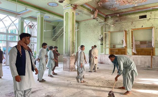 They collect the damage perpetrated by the suicide bombing in the Kandahar mosque.