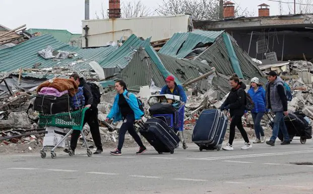 Civilians trapped in Mariupol drag their belongings to flee the bombing that has devastated this port city.