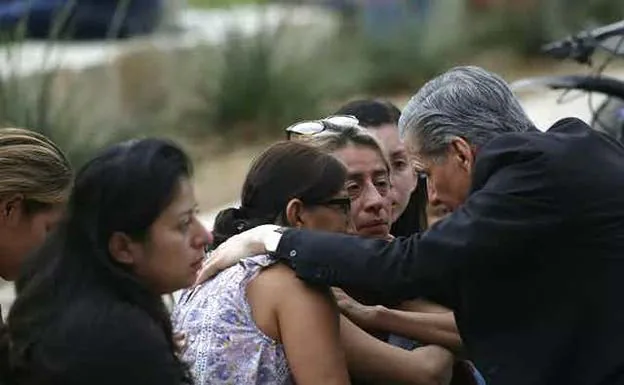 A reverend attends to the families of the victims. 