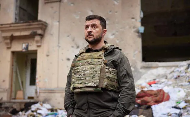 Ukrainian President Volodymyr Zelensky stands before a ruined building in the Kharkiv region during his visit to the eastern front of the war on Sunday.