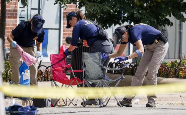 Agents recover evidence at the scene of the shooting in Highland Park. 
