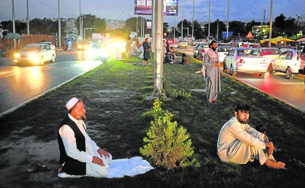 A group of Muslims pray on the shoulder of a road in Kabul.