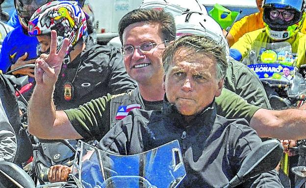 Bolsonaro drives a motorcycle during a campaign rally. 