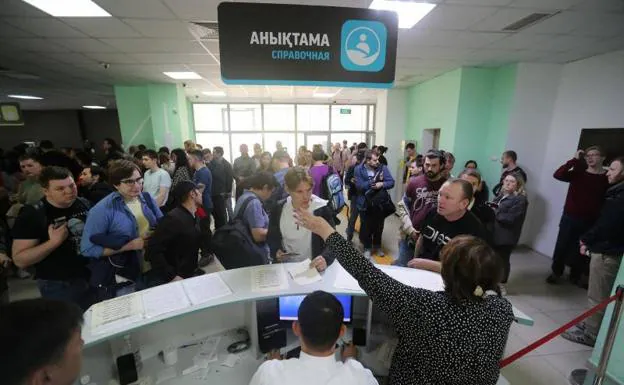 Russian citizens fleeing to Kazakhstan to escape the partial mobilization decreed by Putin queue at an Almaty center to receive a temporary residence document.  Hundreds of thousands of Russians have fled the country in recent days