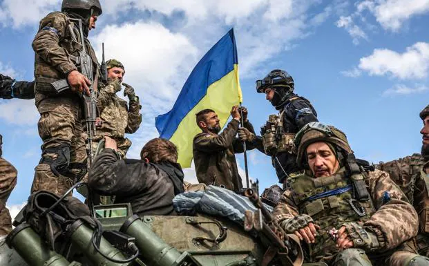 Ukrainian infantrymen place their flag on an armored vehicle on a road near Liman. 