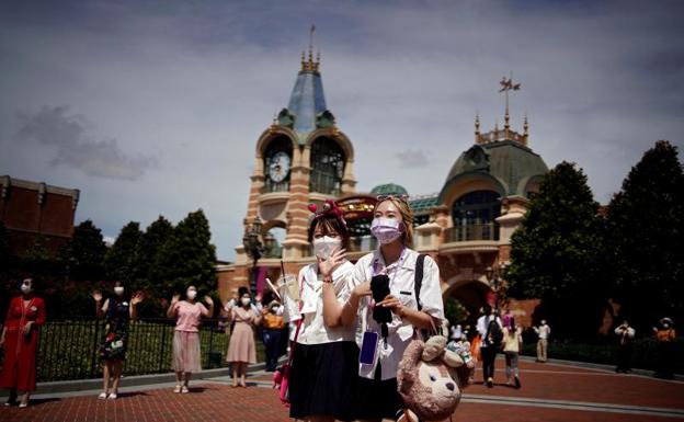 Two young people, wearing a mask, at Disneyland Shanghai. 