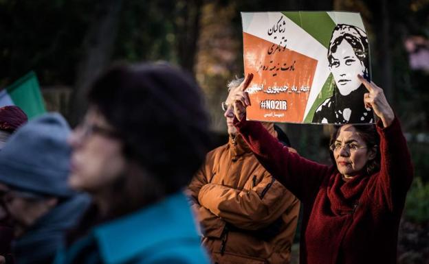 A woman holds a sign in support of Mahsa Amini during a demonstration outside the House of Representatives in The Hague. 