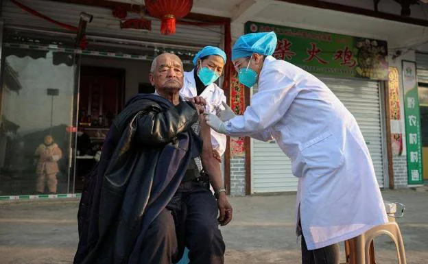 Health personnel vaccinate a neighbor in Guizhou province against covid this week.