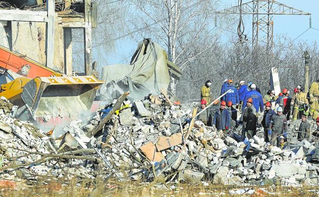 Workers remove rubble from a building destroyed by Ukraine that was allegedly a vocational school used as temporary accommodation for Russian soldiers.