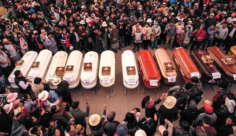 The lined up coffins wait at the Carlos Monge hospital for the bodies of the 18 dead in the massacre on Monday in Juliaca to be delivered
